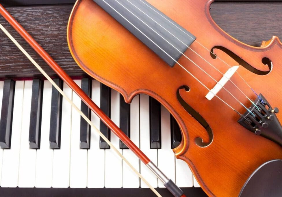 A violin and piano keyboard on top of the floor.