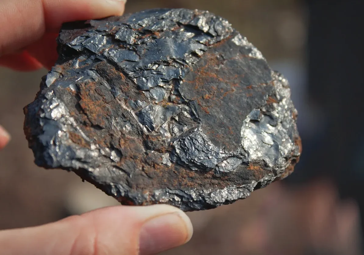 A person holding a piece of metal in their hand.